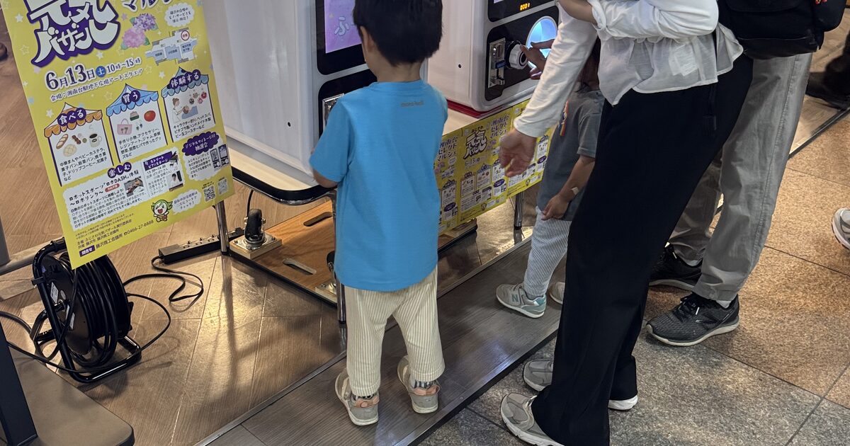 景品が当たるデジタルガチャに参加する子ども連れの来場者