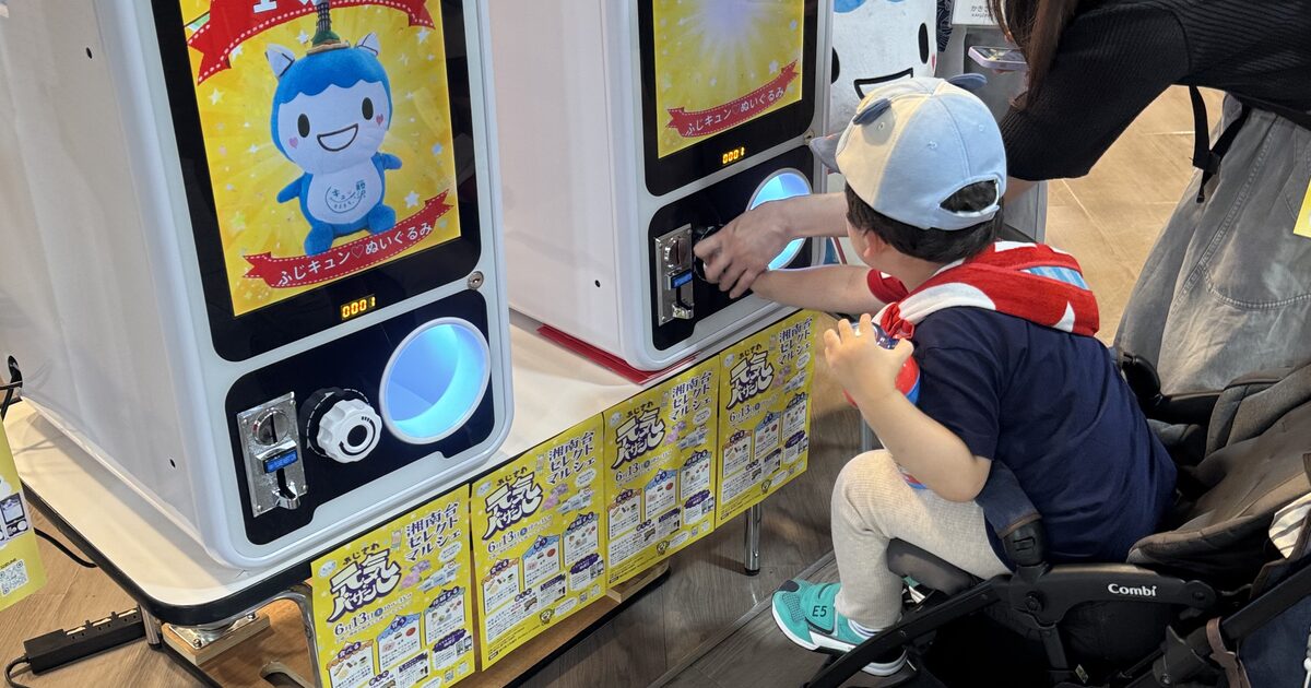 デジタルガチャマシンで景品を選ぶ来場者